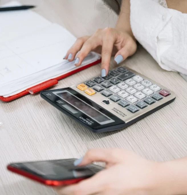 a person using a calculator and a phone